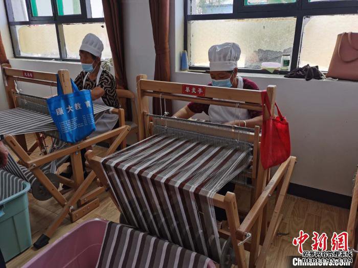 自从建起纺织车间后，东张村组织贫困户进行传统布料“母捻”的纺织加工。　吴琼 摄